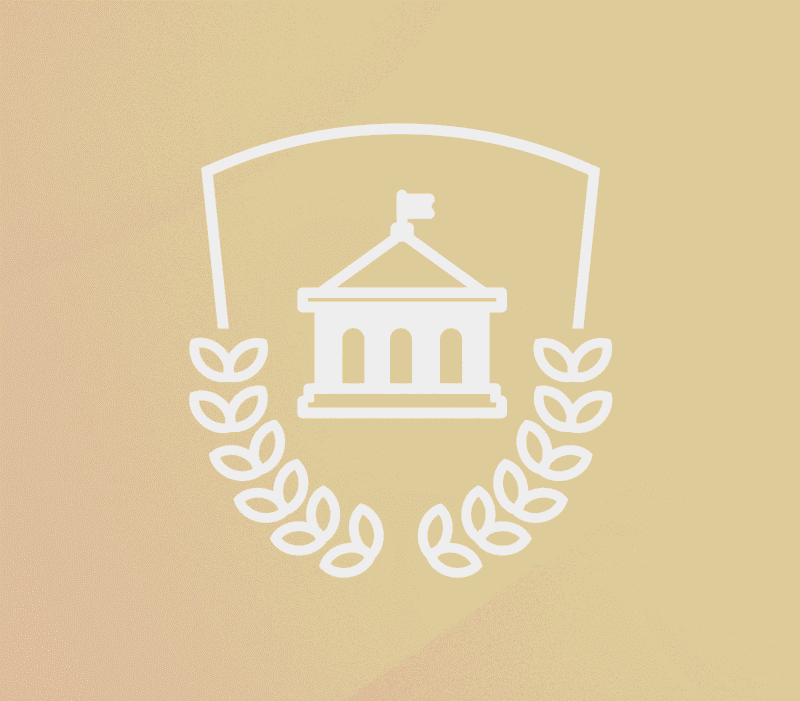 Stylized academic crest icon featuring a classical campus building with a flag, framed by a shield outline and laurel wreath, set against a soft beige gradient background.