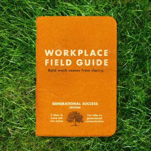Orange booklet titled “Workplace Field Guide” lying on green grass. The cover reads “Bold work comes from clarity” and “Generational Success Edition,” with smaller text about moving talk into action and generational communication alongside a tree illustration.